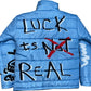 “Luck Is Not Real" Baby Blue Graffiti Puffer Jacket